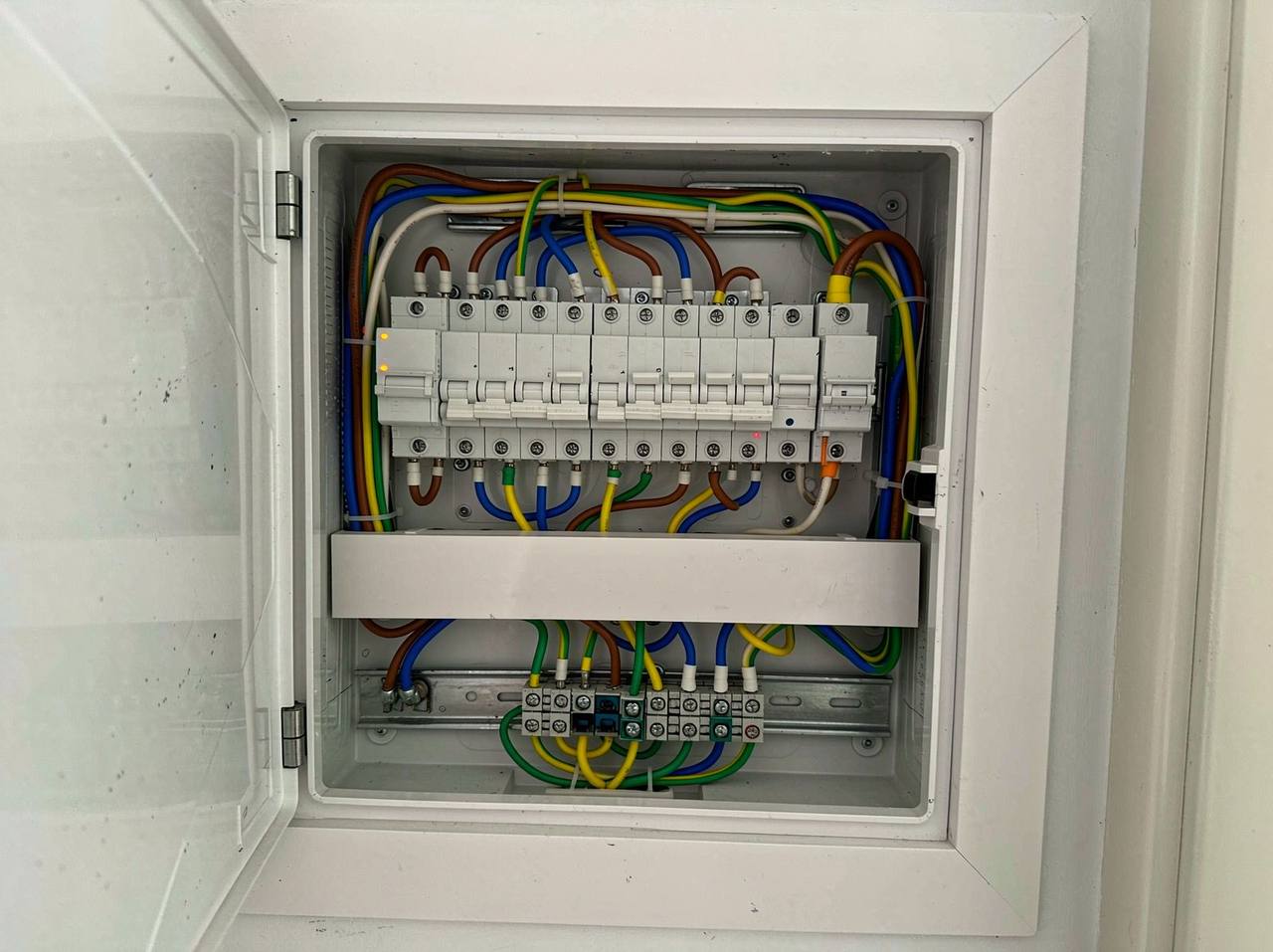 An open breaker panel with one orange indicator light